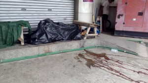Tinakpan na lamang ng itim na lona ang bangkay ng security guard na si Julius Morales matapos itong tadtarin ng saksak sa katawan ng dalawang kawatan sa Zamboanga City. (Mindanao Examiner Photo - Ely Dumaboc)